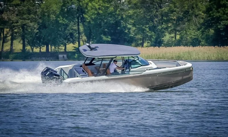 Slide: The Image of 2024 Saxdor 270 GTO motorboat cruising on a lake with lush greenery in the background. - 1