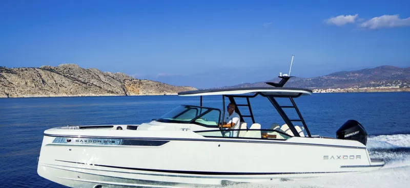 Slide: The Image of 2024 Saxdor 270 GTO cruising on a serene blue sea with rocky coastline in the background. - 3