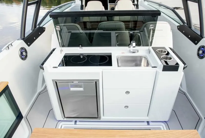 Slide: The Image of 2024 Saxdor 270 GTO boat interior with kitchenette, featuring stove, sink, and storage. - 7
