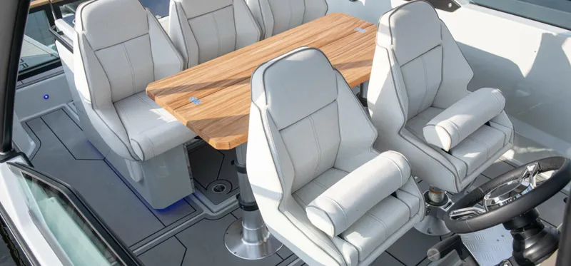 Slide: The Image of Interior of 2024 Saxdor 270 GTO boat with white seating and wooden table. - 8