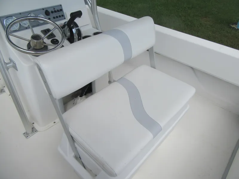 Slide: The Image of 2013 Sundance B20CCR boat interior with white seating and steering console. - 13