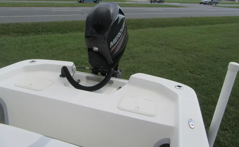 Slide: The Image of 2013 Sundance B20CCR boat with Mercury outboard motor, parked on grass near a road. - 15