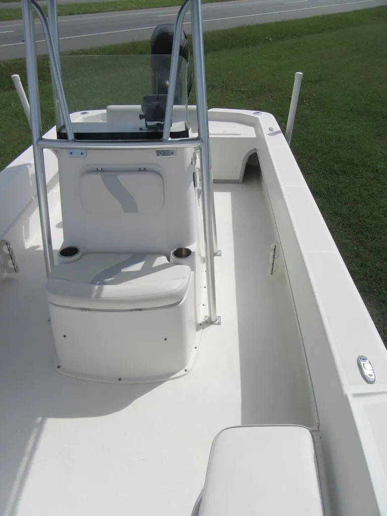 Slide: The Image of 2013 Sundance B20CCR boat interior with seating and console, on grassy area. - 8