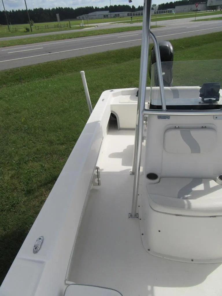 Slide: The Image of 2013 Sundance B20CCR boat, white deck, near a road and grassy area. - 9