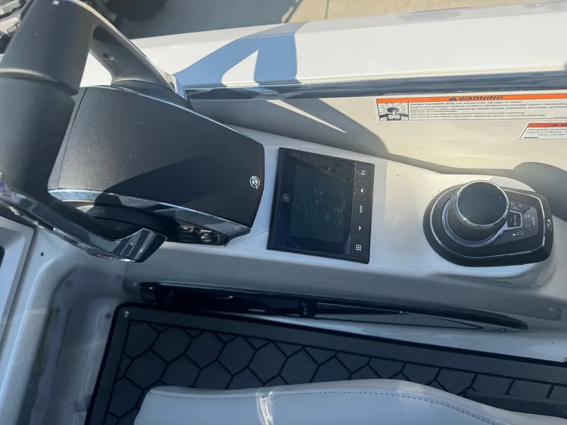 Slide: The Image of 2024 Manitou 27 XT RFXW boat dashboard with steering wheel and control panel. - 13