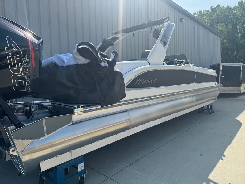 Slide: The Image of 2024 Manitou 27 XT RFXW pontoon boat with powerful outboard motor, parked outdoors. - 2