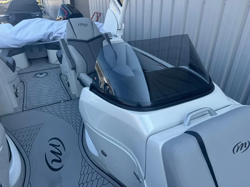 Slide: The Image of 2024 Manitou 27 XT RFXW boat interior with sleek seating and modern design. - 8