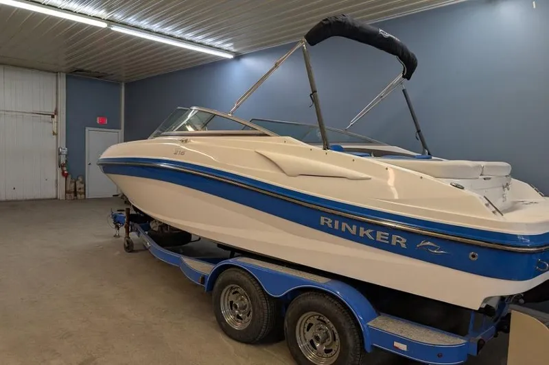 Slide: The Image of 2012 Rinker Captiva 216 BR boat in indoor storage, blue and white design. - 1