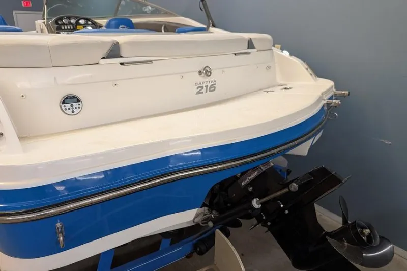 Slide: The Image of 2012 Rinker Captiva 216 BR boat, blue and white exterior, rear view with motor. - 12