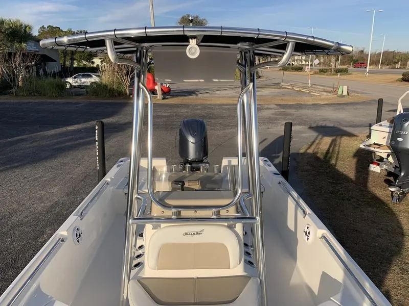 Slide: The Image of 2025 Bulls Bay 2200 XS boat with T-top and outboard motor, parked on a trailer. - 25