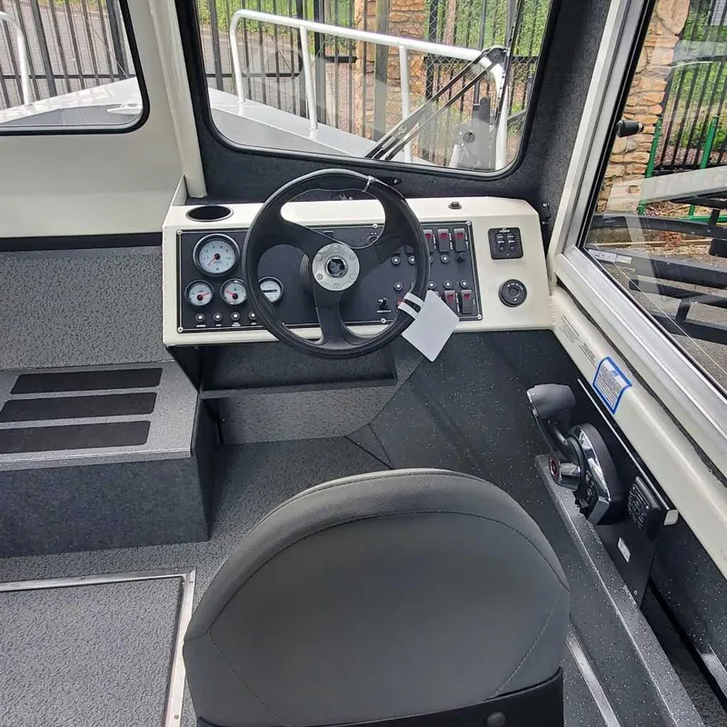 Slide: The Image of 2024 Spartan 240 Maximus Pro boat cockpit with steering wheel and control panel. - 4