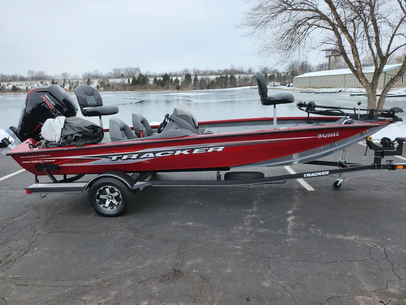 The Image of 2019 Tracker Pro Team 190 TX Tournament Edition boat on trailer by a lake. - 0