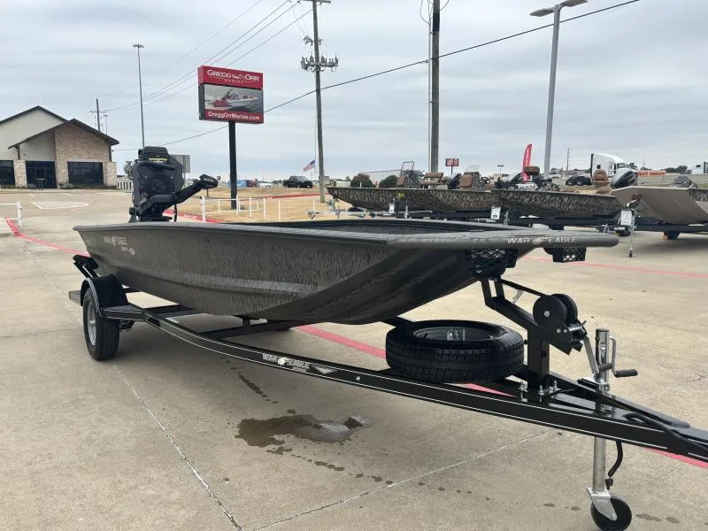 Slide: The Image of 2025 War Eagle 750 Gladiator boat on trailer in dealership lot. - 2
