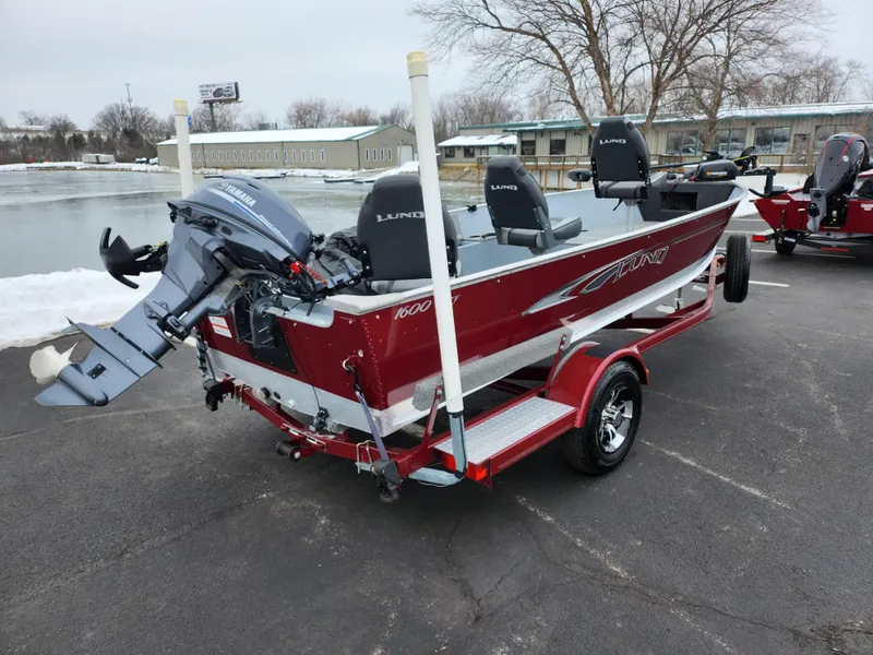 Slide: The Image of 2019 Lund 1600 Fury Tiller boat on trailer, parked near a lake. - 1