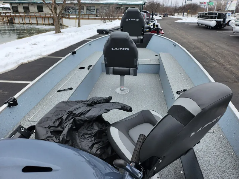 Slide: The Image of 2019 Lund 1600 Fury Tiller boat with seating, parked near snowy waterfront. - 11