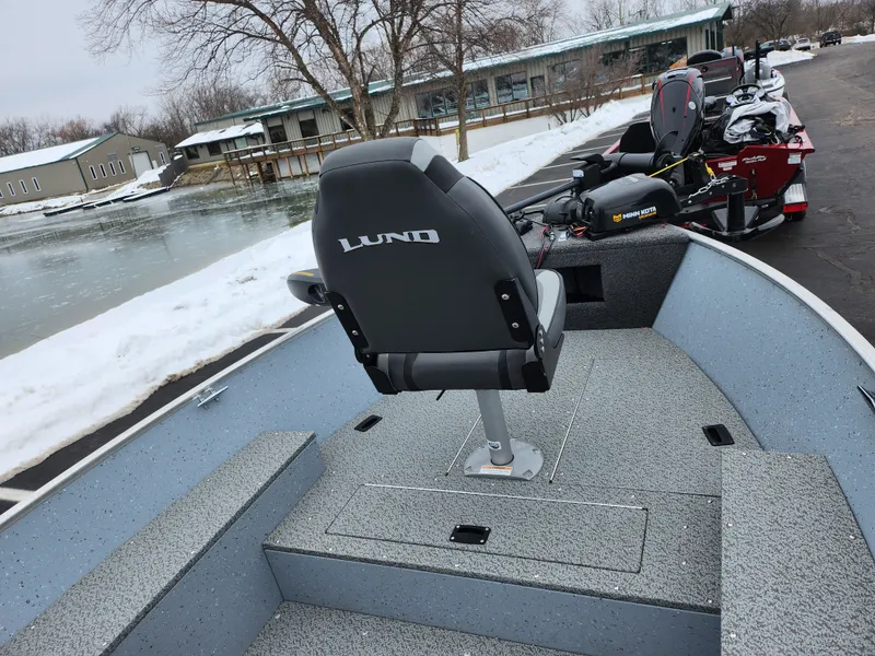 Slide: The Image of 2019 Lund 1600 Fury Tiller boat with a single seat, near a snowy lakeside. - 12
