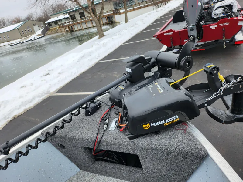 Slide: The Image of 2019 Lund 1600 Fury Tiller with Minn Kota motor, parked near snowy lake. - 13