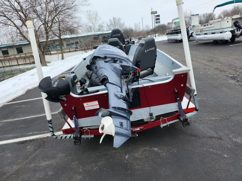 Slide: The Image of 2019 Lund 1600 Fury Tiller boat with outboard motor in a parking lot. - 2