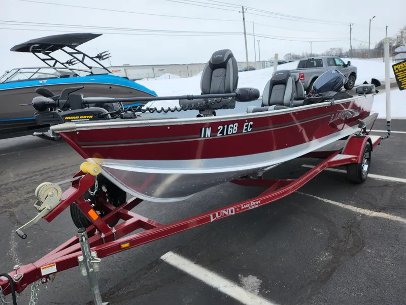 Slide: The Image of 2019 Lund 1600 Fury Tiller boat on trailer, red and silver, parked outdoors. - 6