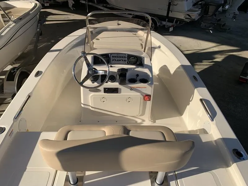 Slide: The Image of 2025 Scout 177 Sport boat storage compartment with open lid and cooler inside. - 5