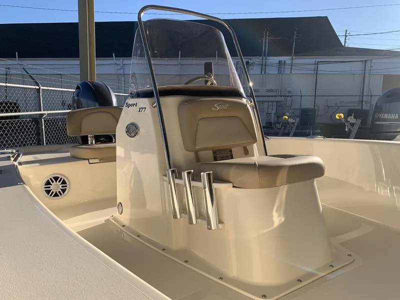 Slide: The Image of 2025 Scout 177 Sport boat interior with beige seating and steering console. - 8