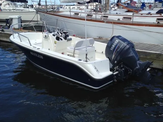 Slide: The Image of 2011 Edgewater 170CC boat docked, featuring Yamaha outboard motor, sleek design, and spacious deck. - 0