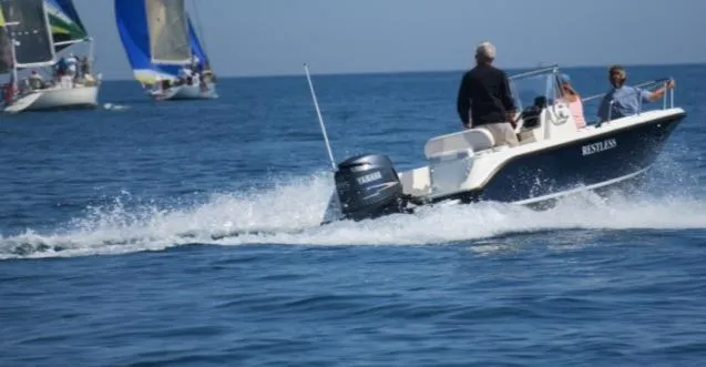 Slide: The Image of 2011 Edgewater 170CC boat cruising on open water with sailboats in the background. - 20