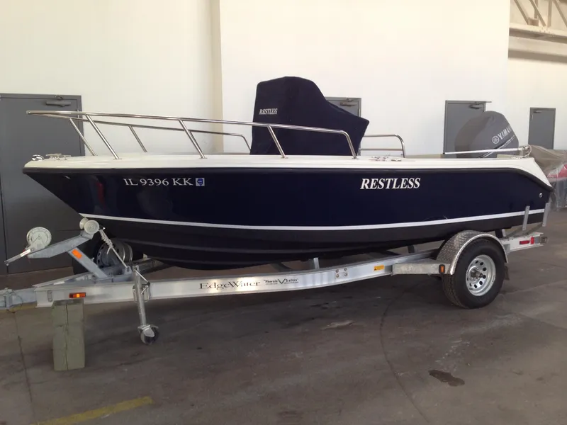 Slide: The Image of 2011 Edgewater 170CC boat named "Restless" on a trailer in a garage. - 3