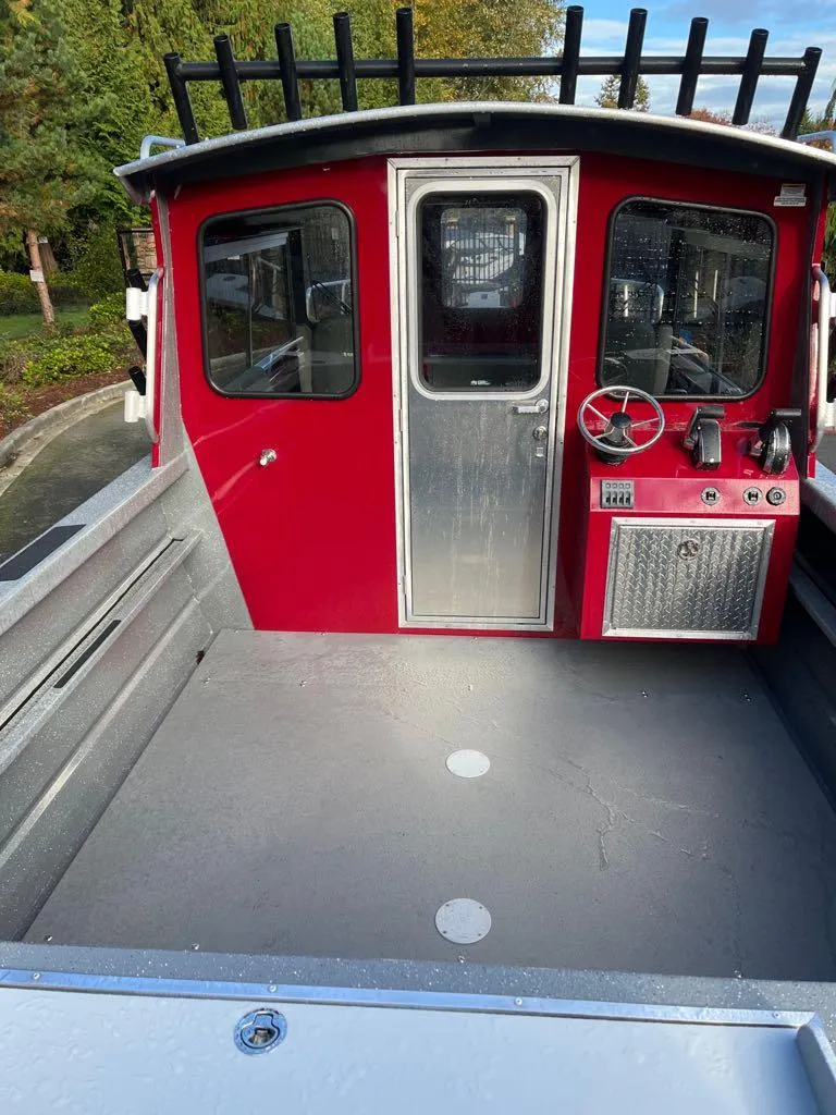 The Image of 2024 Spartan Maximus 240 boat with red cabin and spacious deck. - 2