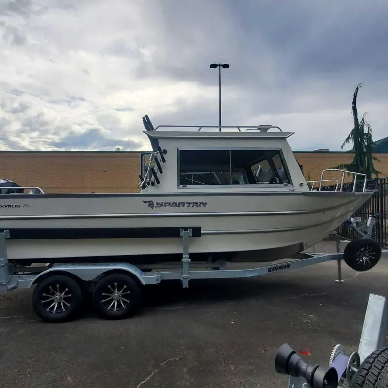 Slide: The Image of 2024 Spartan Maximus 240 boat on trailer, parked outdoors under cloudy sky. - 6
