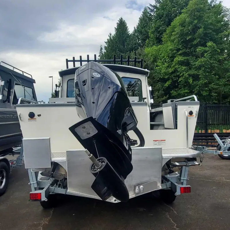 Slide: The Image of 2024 Spartan Maximus 240 boat with powerful outboard motor, parked outdoors. - 7