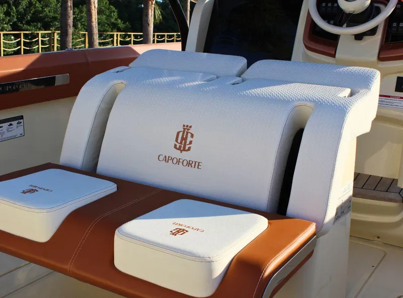Slide: The Image of 2024 Capoforte FX270 boat interior with branded white and brown seating. - 10