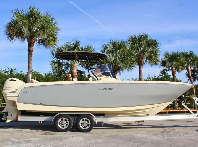 Slide: The Image of 2024 Capoforte FX270 boat on trailer, palm trees in background. - 2