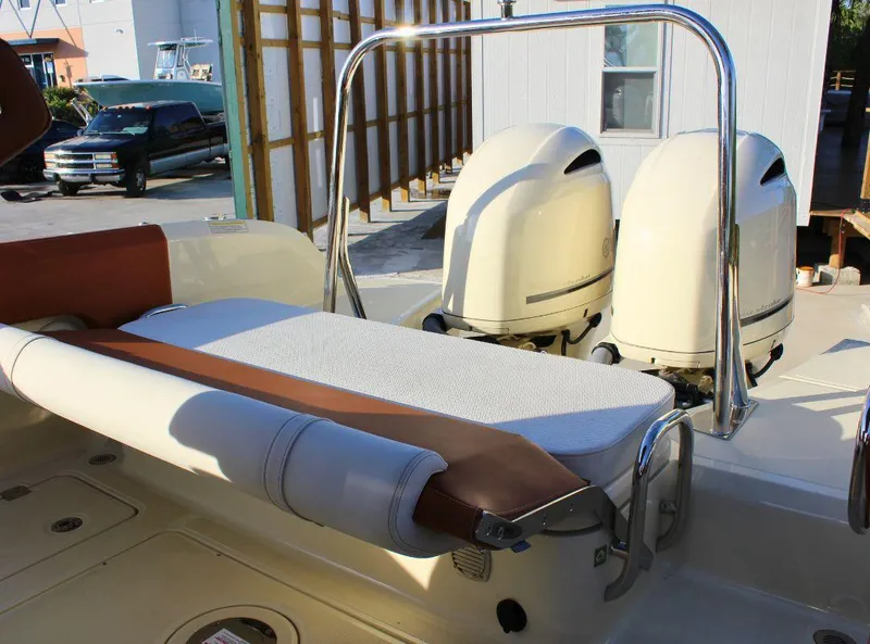 Slide: The Image of 2024 Capoforte FX270 boat with dual engines and cushioned seating, docked outdoors. - 9