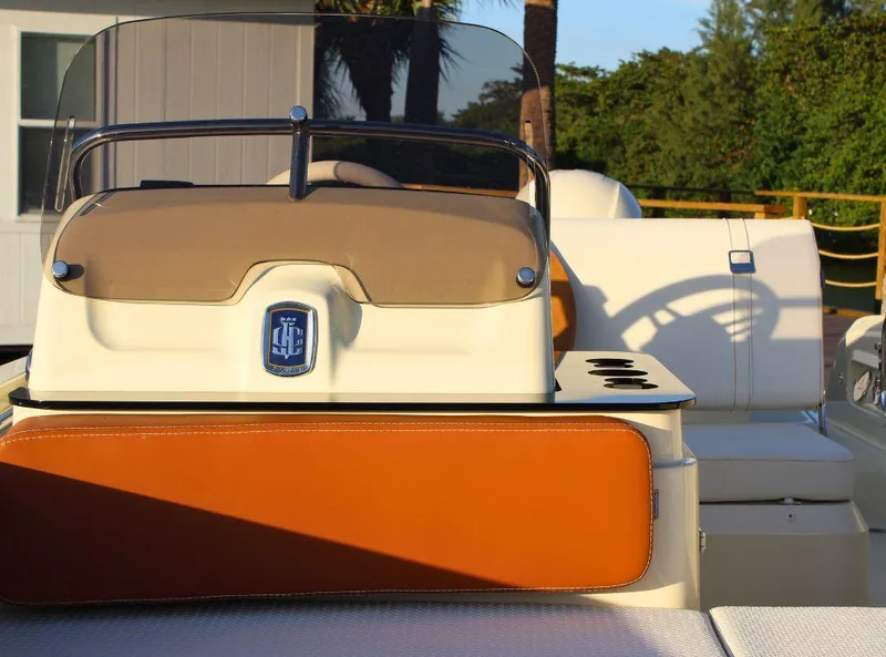 Slide: The Image of 2024 Capoforte SX200 boat interior with tan and orange seating, steering console, and cup holders. - 18