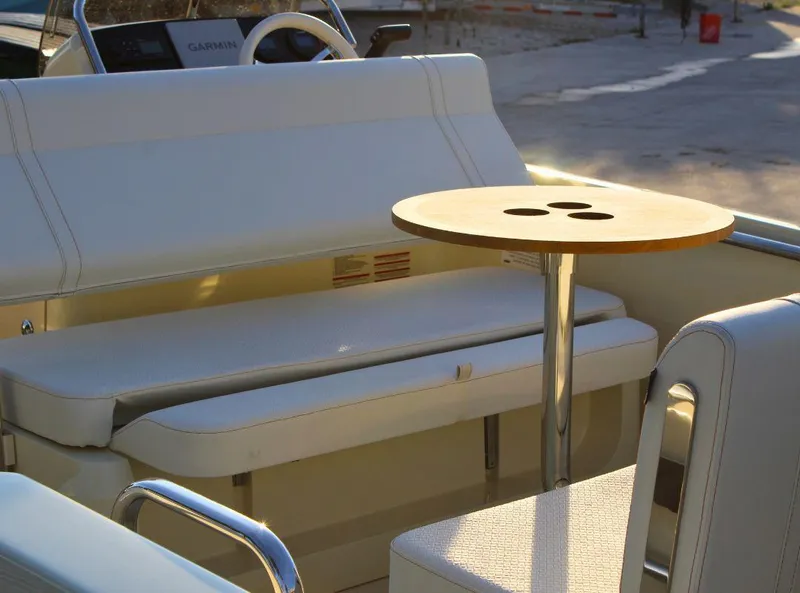 Slide: The Image of 2024 Capoforte SX200 boat interior with seating and a small table. - 5