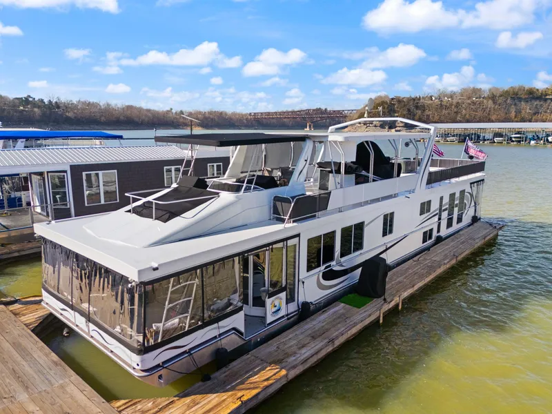 Slide: The Image of 2011 Horizon 18 X 82 houseboat docked on a sunny day, featuring spacious decks. - 0