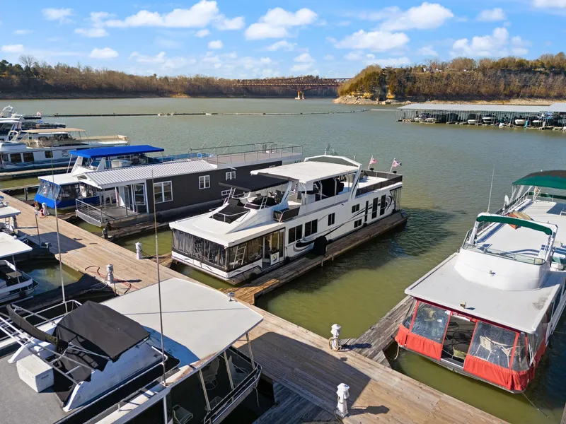 Slide: The Image of Houseboats docked on a serene lake, featuring a 2011 Horizon 18 X 82 model. - 10