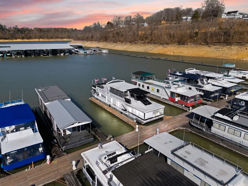 Slide: The Image of Houseboats docked at a marina during sunset, featuring a 2011 Horizon 18 X 82 model. - 11
