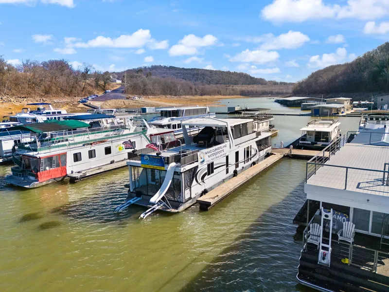 Slide: The Image of Houseboats docked on a serene lake, featuring a 2011 Horizon 18 X 82 model. - 7