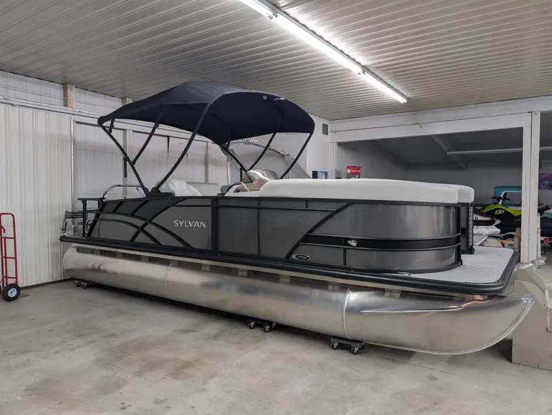 Slide: The Image of 2025 Sylvan Mirage 8522 CLZ pontoon boat in indoor storage with canopy. - 1