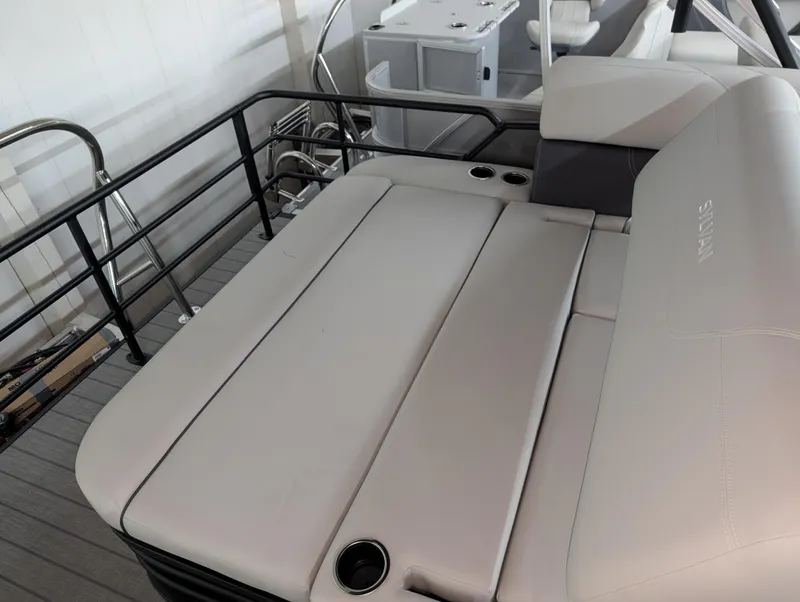 Slide: The Image of 2025 Sylvan Mirage 8522 CLZ boat interior with cushioned seating and railing. - 9