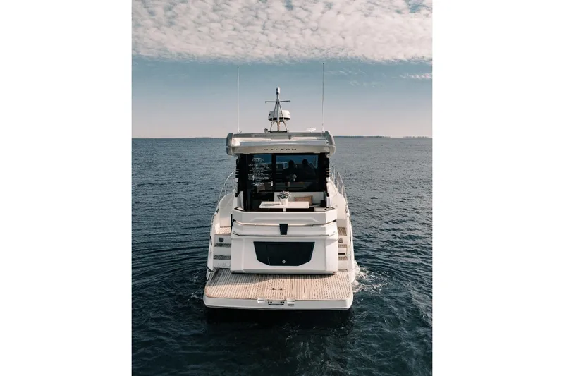 Slide: The Image of 2024 Galeon 425 HTS yacht cruising on open water under a partly cloudy sky. - 20