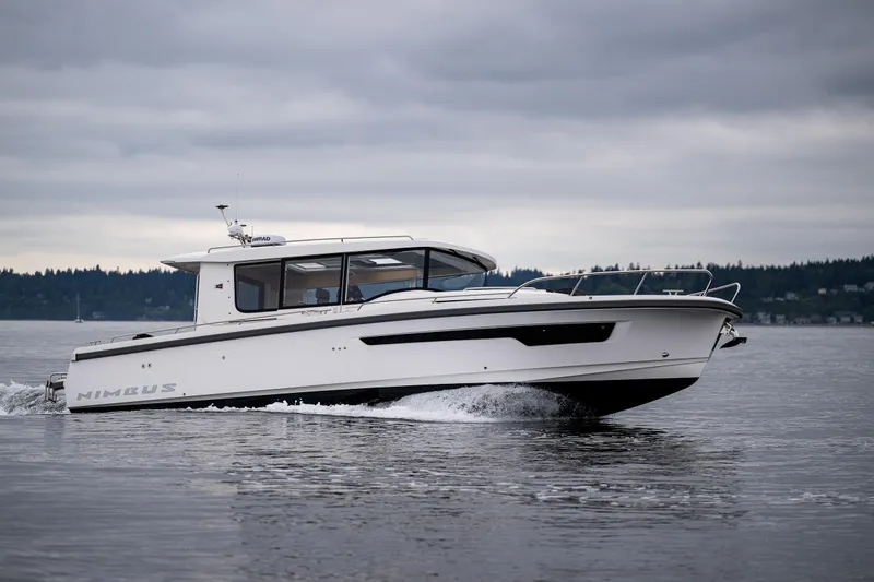 Slide: The Image of 2022 Nimbus C11 boat cruising on a calm lake under cloudy skies. - 1