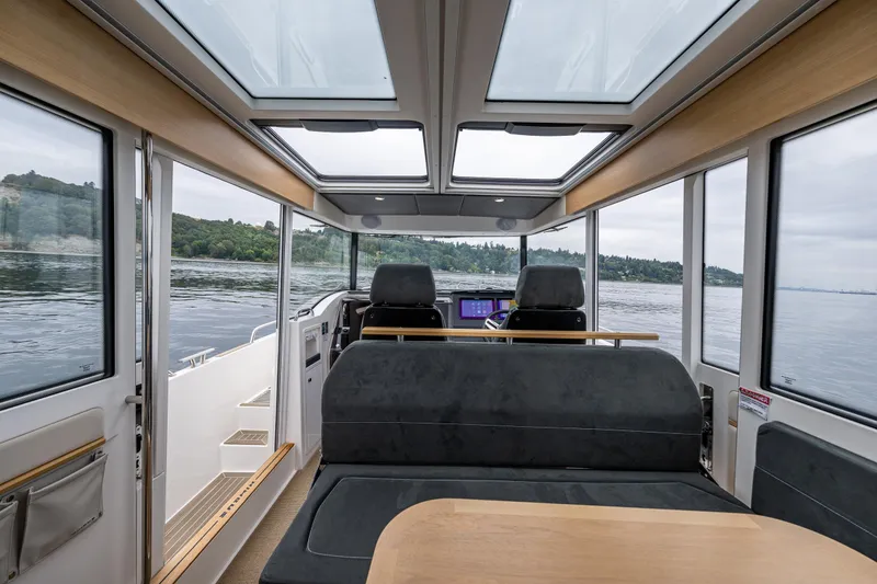 Slide: The Image of Interior of 2022 Nimbus C11 boat with panoramic windows and modern seating. - 10