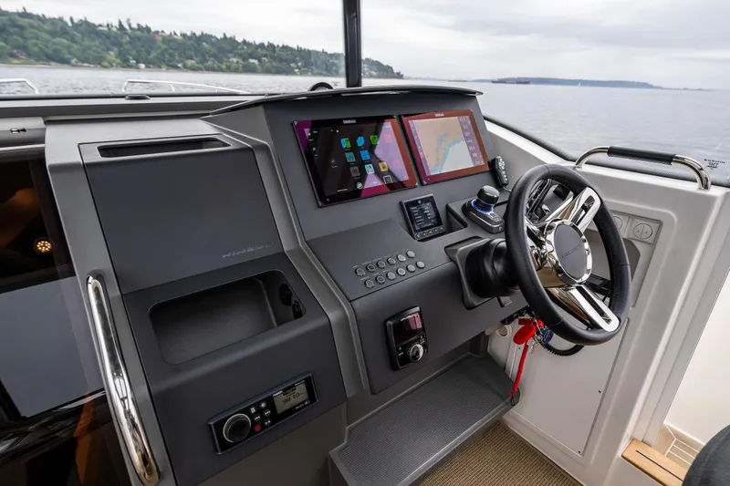 Slide: The Image of 2022 Nimbus C11 boat dashboard with modern navigation screens and steering wheel. - 14