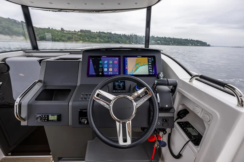 Slide: The Image of 2022 Nimbus C11 boat dashboard with modern navigation screens and steering wheel. - 15