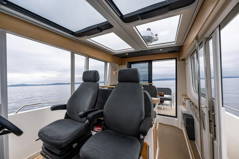 Slide: The Image of Interior of 2022 Nimbus C11 boat with panoramic windows and comfortable seating. - 17