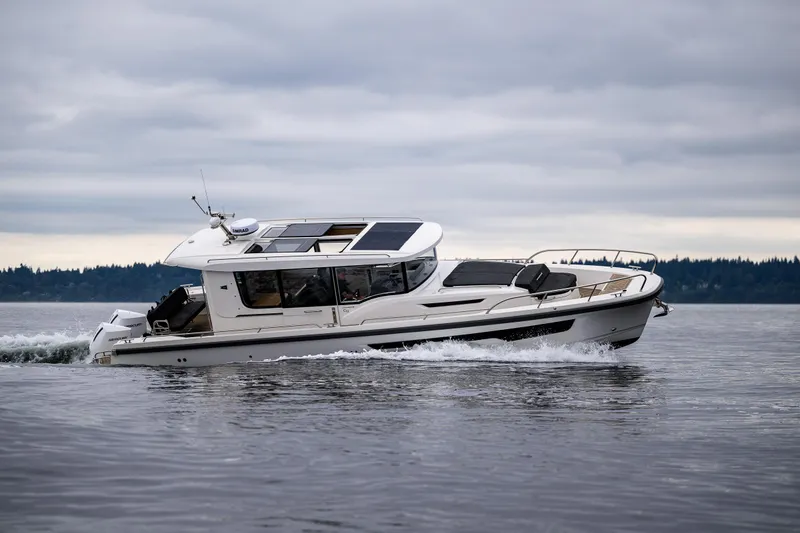 Slide: The Image of Nimbus C11 2022 boat cruising on a calm lake under cloudy skies. - 2