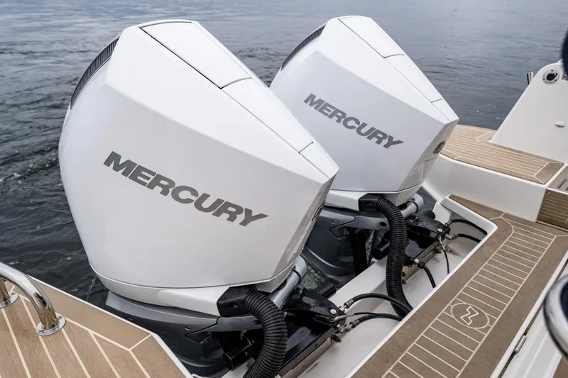 Slide: The Image of Twin Mercury outboard engines on a 2022 Nimbus C11 boat, docked on water. - 29